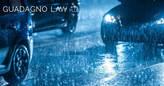 cars driving in downpour at night